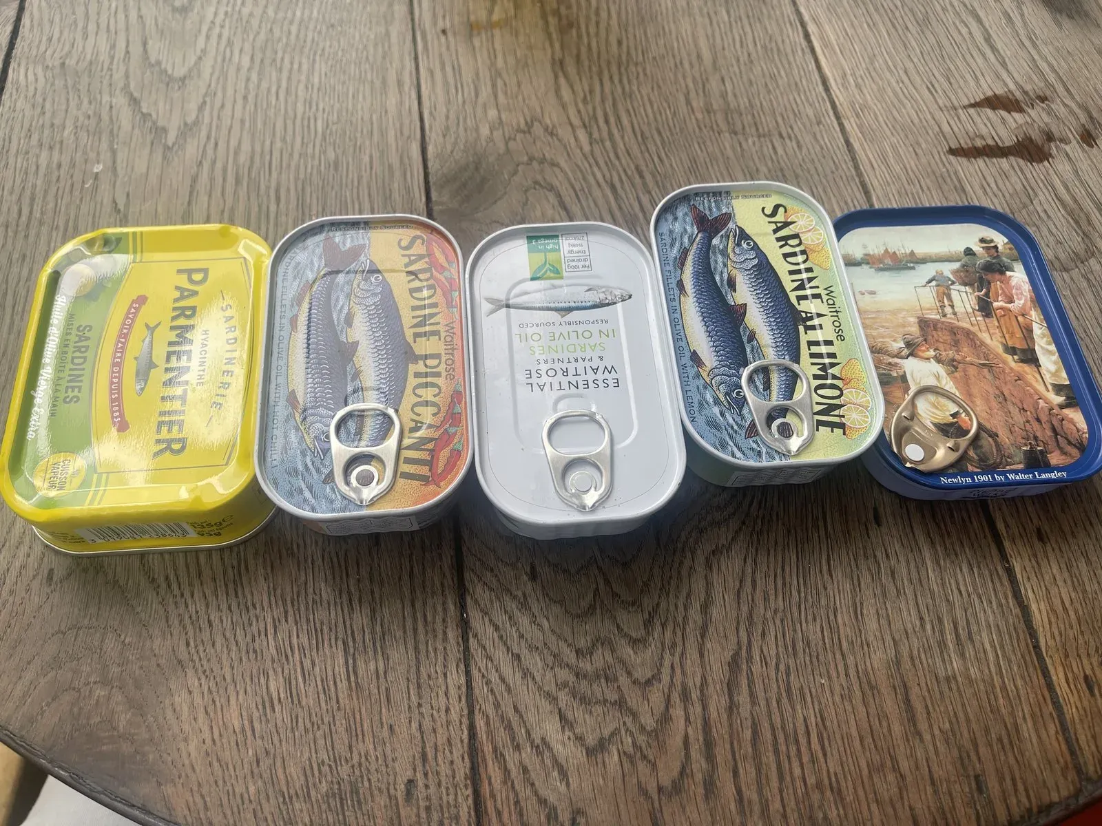 A row of sardine tins laid out on the author's kitchen table
