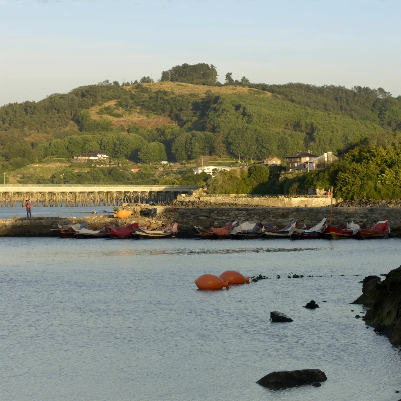 Illustrated coastal scene evoking Spain, home of La Brújula